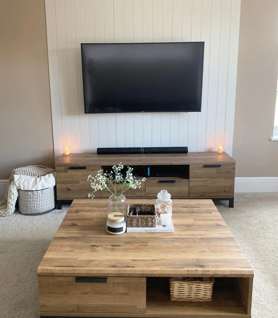 White V groove panel TV wall above a rustic oak TV unit and matching coffee table with candles